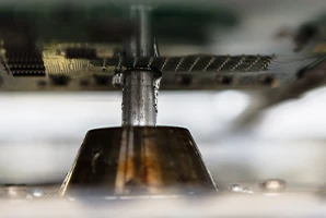 Selective soldering machine for THT assembly of electronic boards that already have SMD (surface mounted devices) components on one side. The electronic boards are held above the solder jet by a special solder frame.